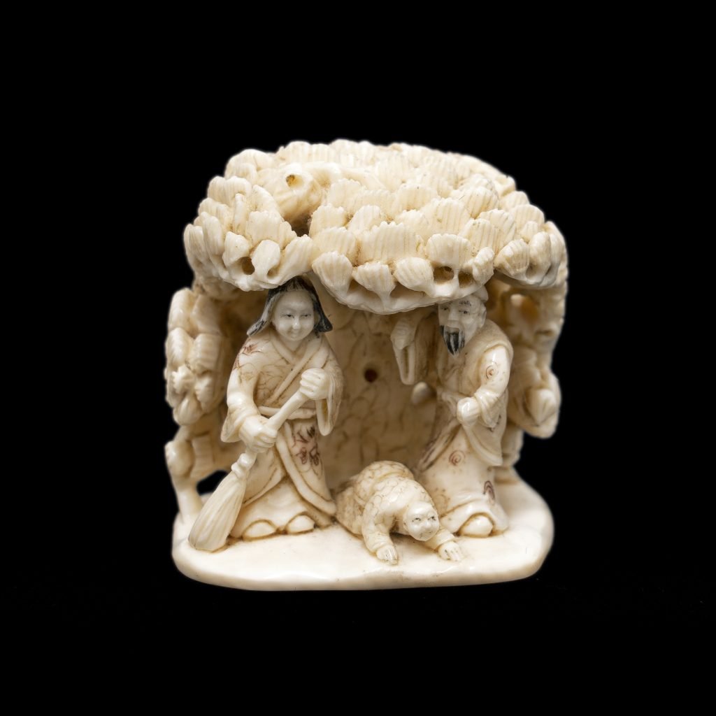 Netsuke en ivoire de mammouth, la famille sous un pin