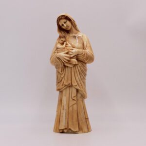 sculpture en os montre une vierge à l’allure maternelle berçant un enfant avec tendresse et bienveillance.